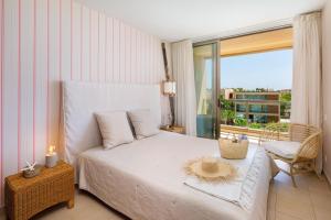 a bedroom with a white bed and a balcony at Salgados Vila das Lagoas in Albufeira