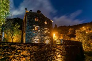 an old stone building with lights on it at night at Casa do Talasnal in Lousã