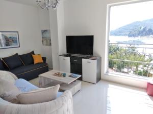 a living room with a couch and a large window at Apartment Galina in Tivat