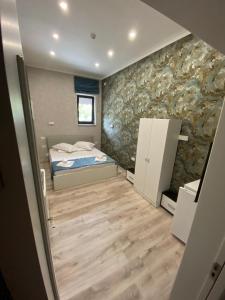 um quarto com uma cama e uma parede de pedra em Arizet Boutique Mamaia em Mamaia