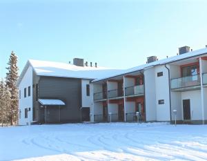 an apartment building with snow on the ground at Lapland Happiness Skistar 201 in Äkäslompolo