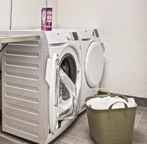 eine Waschmaschine neben einem Wäschekorb in der Unterkunft Lapland Happiness Skistar 201 in Äkäslompolo
