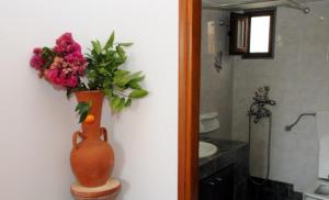 a vase with flowers sitting on a table in a bathroom at Studios Cavo Doro in Otziás