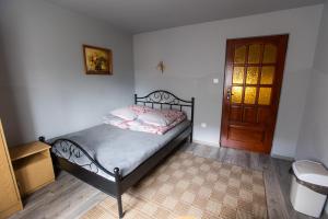 um quarto com uma cama e uma porta de madeira em U Haliny em Biały Dunajec