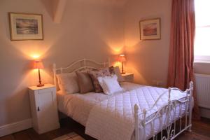 a bedroom with a white bed with two lamps at The Manor House Bed and Breakfast in Castle Acre
