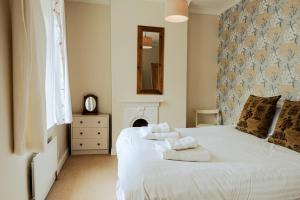 1 dormitorio con 1 cama con toallas en Painter's Cottage, en Matlock Bank