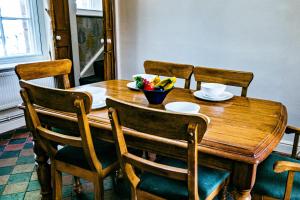 einen Holztisch mit Stühlen und eine Schale mit Obst darauf in der Unterkunft Painter's Cottage in Matlock Bank + 24 Fotos