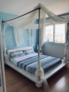 un letto a baldacchino bianco in una stanza con finestra di Heron apartments a Lido di Jesolo