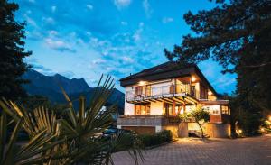 ein Haus mit Balkon in der Nacht mit Bergen in der Unterkunft Garni Hotel Torkelbündte in Bad Ragaz