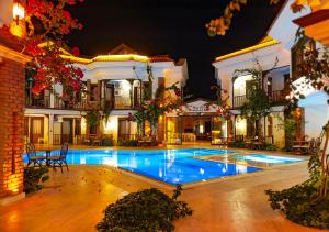 ein großes Haus mit Swimmingpool in der Nacht in der Unterkunft Dalyan Hotel Nish Caria in Dalyan