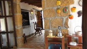 a room with a stone wall with a table and a chair at Finca Casa Loma Barichara in Barichara