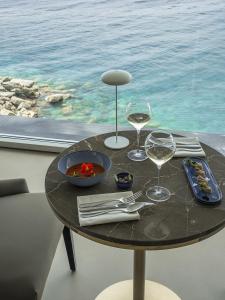 a table with two glasses of wine on it with a view of the ocean at Sublimis Boutique Hotel Adults-Only in Camogli