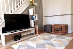 a living room with a flat screen tv on a entertainment center at Clement's Retreat on the North Norfolk Coast in Cromer