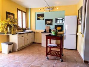RelleuにあるLa Masia dels Artistesの黄色の壁のキッチン(白い冷蔵庫付)