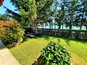 un patio con una valla y un banco y un arbusto en Spacious Apartment "Ana" on lake Sabljaci, en Ogulin