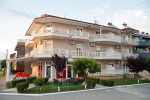 a large building with white balconies on a street at Villa Morfeas in Paralia Katerinis