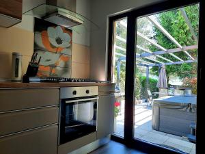 a kitchen with a stove top oven next to a window at Spacious Apartment "Ana" on lake Sabljaci in Ogulin