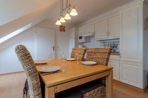 a dining room with a wooden table and chairs at Ferienwohnung-7-Auszeit-in-der-Villa-Annabelle in Binz +9 photos