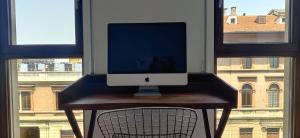 an apple computer sitting on a desk in front of a window at B&B Allegra in Bologna