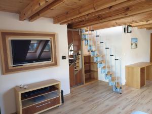a staircase in a room with wooden floors and a tv at Apartamenty & Restauracja NADMORSKA in Krynica Morska