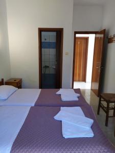 - une chambre avec 2 lits et des serviettes dans l'établissement Filio Sevastatou Rooms, à Therma