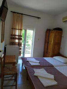 1 dormitorio con cama, mesa y ventana en Filio Sevastatou Rooms, en Therma