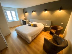 - une chambre avec un lit et deux chaises dans l'établissement Logis Hôtel Restaurant Barrey, à Orchamps-Vennes