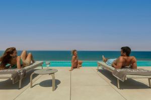 a group of people sitting on lounge chairs at a pool at RH Bayren Hotel & Spa 4* Sup in Gandía