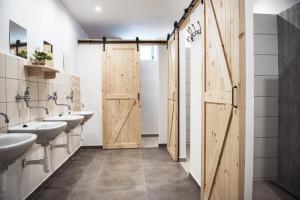 un bagno con tre lavandini e una porta in legno di Stará Pila - Jizerka a Jizerka
