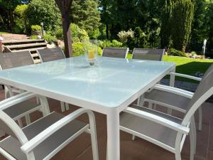 una mesa blanca y sillas con un cristal. en Odenwald Chalet en Erbach