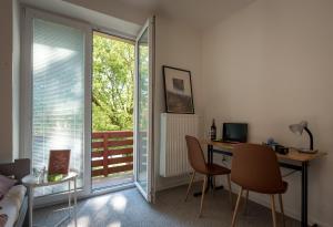 um quarto com uma secretária, uma cama e uma varanda em Hostel 26 em Košice
