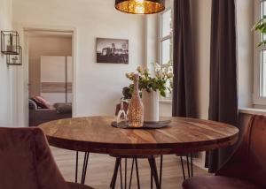 a dining room table with a vase of flowers on it at City Loft in Eisenach