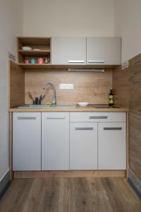 a kitchen with white cabinets and a sink at Hostel 26 in Košice