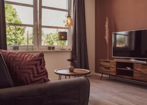 アイゼナハにあるCity Loftのソファ、テレビ、テーブルのあるリビングルーム