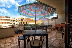 einen Tisch und Stühle mit Sonnenschirm auf einer Terrasse in der Unterkunft B&B PRINCESS ROOM in Capo dʼOrlando