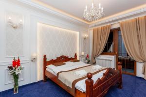 a bedroom with a bed and a chandelier at Penzión Budzák in Ždiar