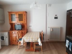 a dining room with a table and a microwave at Appartamenti Abetaia in Dimaro