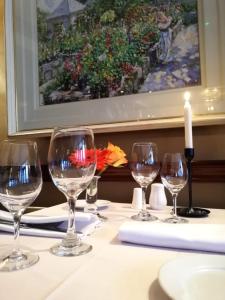 a table with wine glasses on a table with a painting at Foley's Townhouse Killarney in Killarney