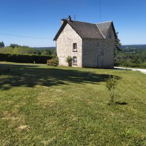 uma velha casa de pedra num campo relvado em Au doux refuge em Saint-Exupéry-les-Roches