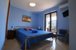 a blue bedroom with a bed with blue sheets and a window at B&B PRINCESS ROOM in Capo dʼOrlando