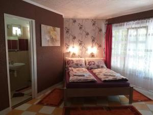 a small bedroom with a bed and a window at Gyöngyvirág Apartment in Romhány