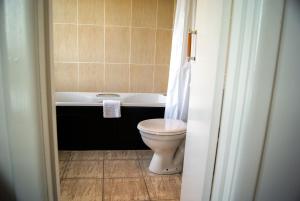 a bathroom with a toilet and a bath tub at Cumberland Hotel - OCEANA COLLECTION in Bournemouth