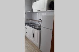 eine Küche mit weißen Schränken und einem Waschbecken in der Unterkunft Acogedor apartamento a 5 minutos de la playa in Aguadulce