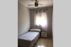 ein kleines Schlafzimmer mit einem Bett und einem Fenster in der Unterkunft Acogedor apartamento a 5 minutos de la playa in Aguadulce