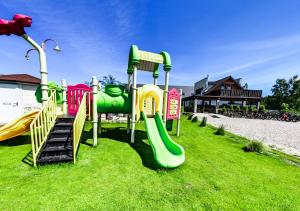 a playground with a slide on the grass at Apartmenty Magnolia in Łeba