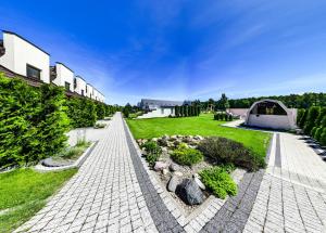 a brick walkway leading to a building with a garden at Apartmenty Magnolia in Łeba