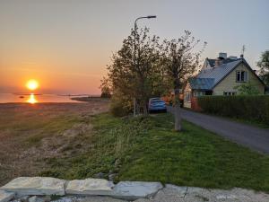 a house on the side of a road with the sunset at Mereääre in Haapsalu