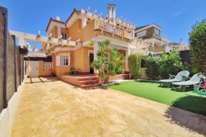 une maison avec une cour et une pelouse dans l'établissement Montefaro Spacious Townhouse - Beach & pool, à Santa Pola