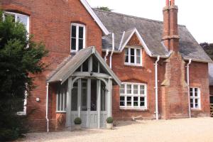 a red brick house with a white door at The Manor House Bed and Breakfast in Castle Acre