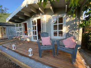 a tiny house with two chairs and a table on a deck at Hygge Lodge Annecy in Doussard